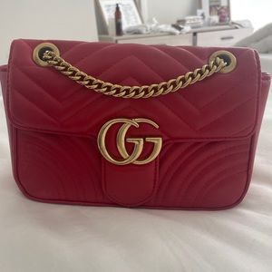 Red pleather designer handbag with brass chain